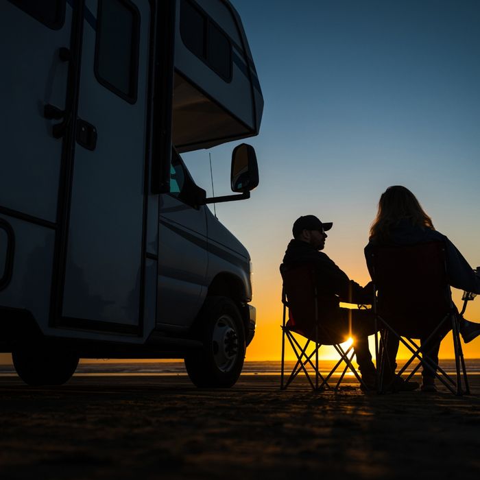 Couple sitting outside their RV watching the sunset