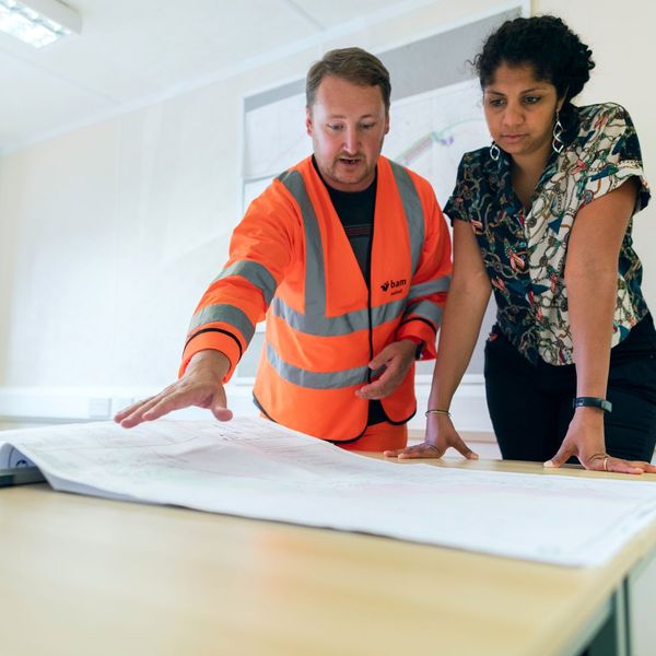 Two people looking over blueprints