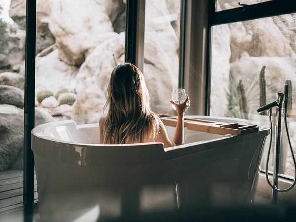 woman treating herself to a bath and wine
