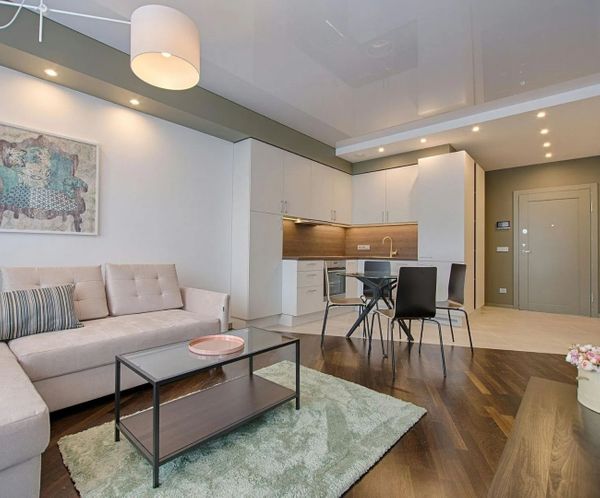 Open concept living area in a finished basement with kitchen and dining space