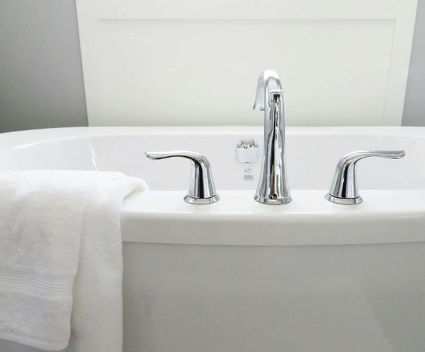 Close-up of a modern white bathtub with sleek chrome faucet Close-up of a modern white bathtub with sleek chrome faucet