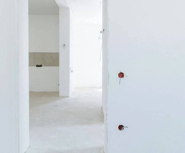 Interior hallway with newly installed drywall and electrical outlets during construction