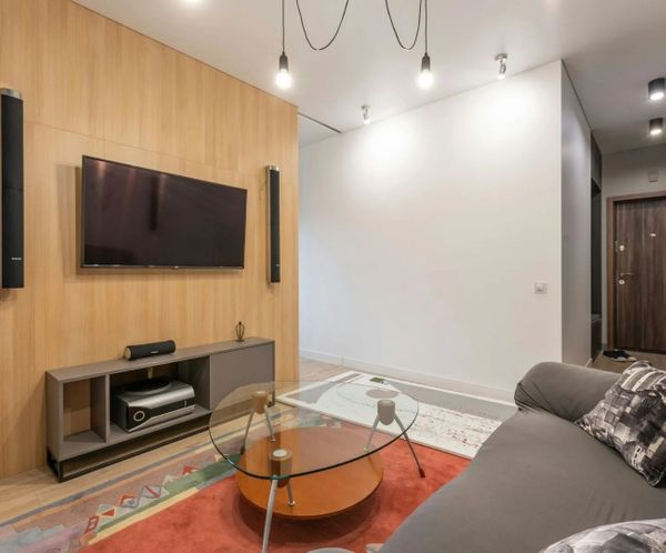Modern basement living room with mounted television and wood accent wall