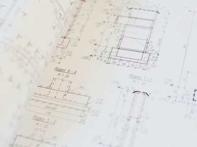 Multiple sheets of detailed engineering and architectural blueprints