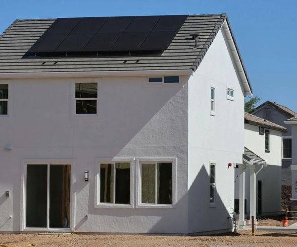 Newly built white residential house with solar panels on the roof