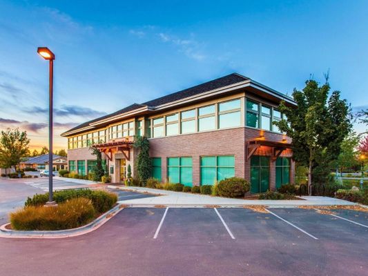 Modern commercial building with large windows and brick exterior at dusk