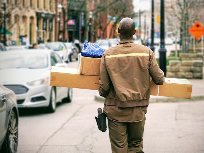 A delivery man holding packages.