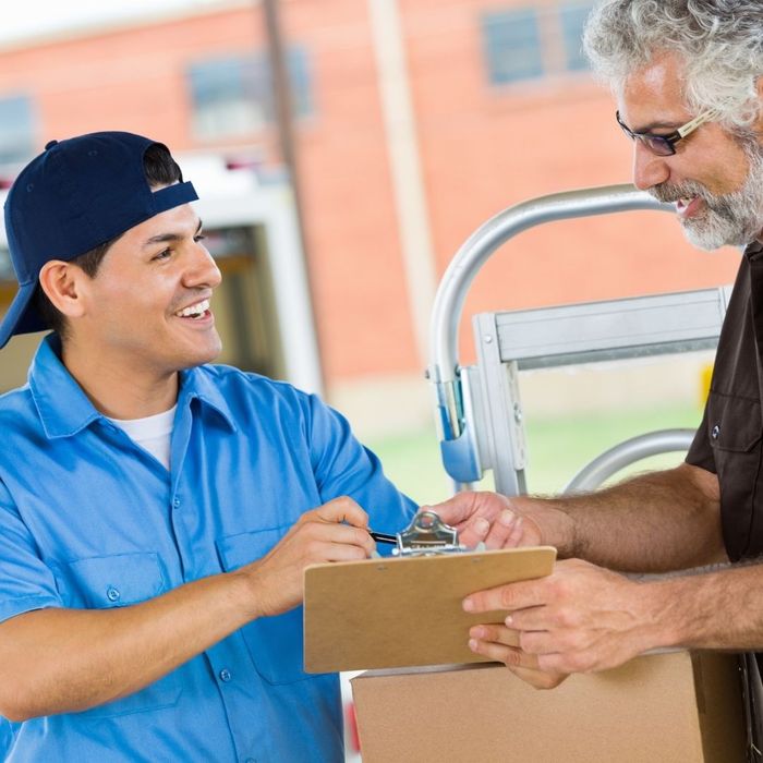 Delivery driver handing a package to a man