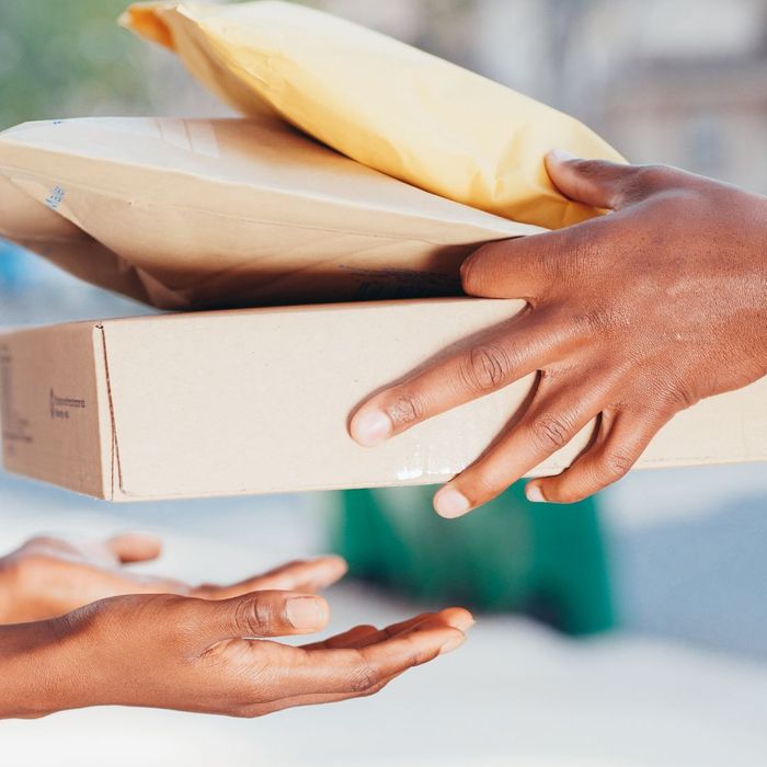 one person handing another person a stack of packages