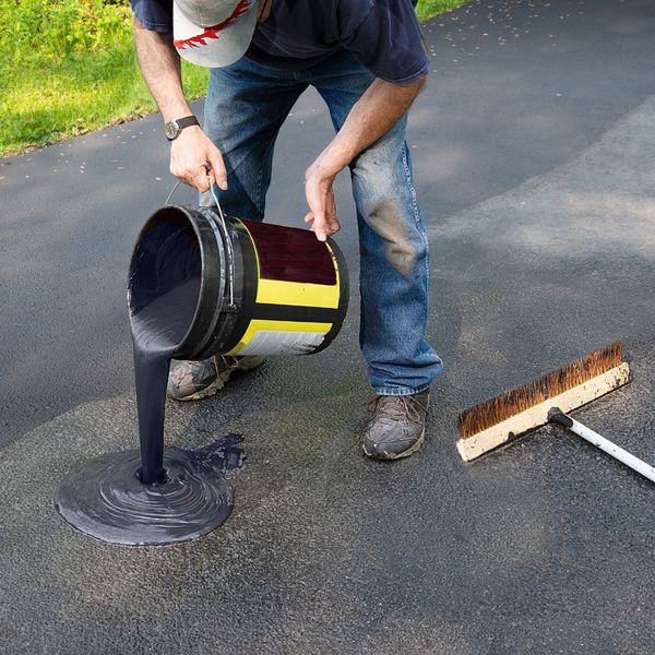 person resurfacing asphalt