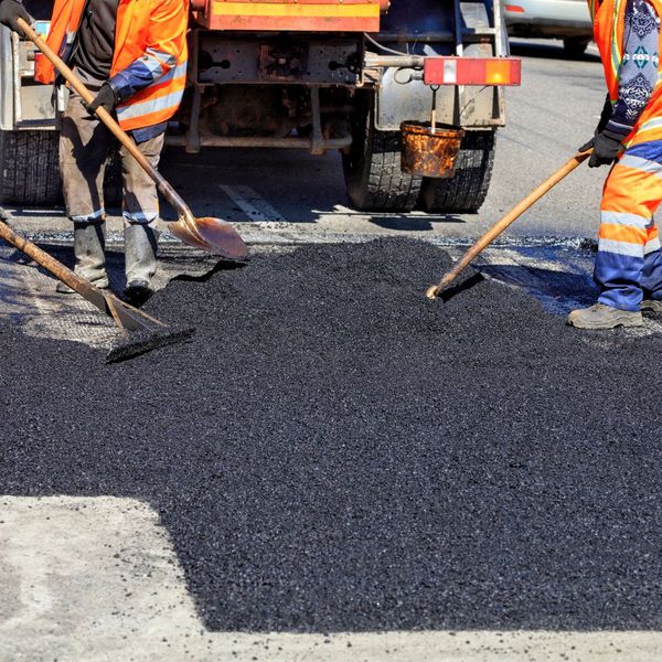 workers putting down asphalt