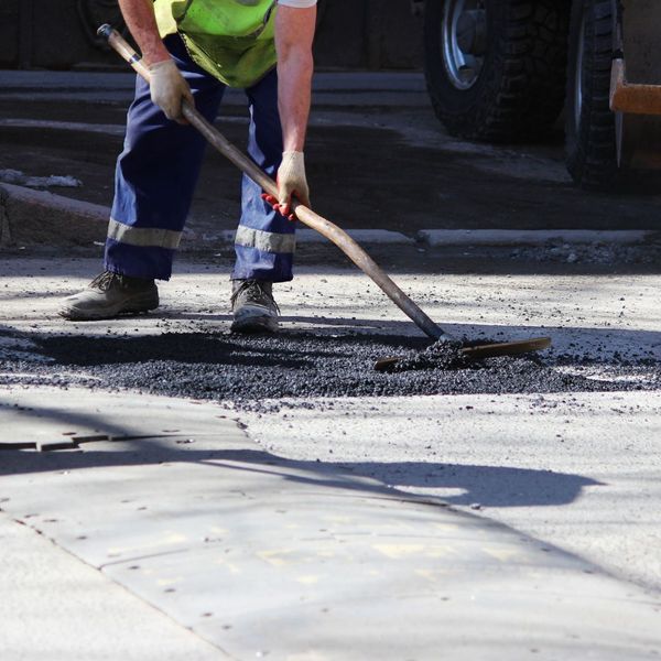 worker putting down asphalt