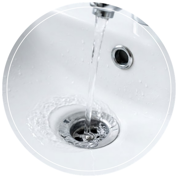 clear water flowing down a freshly cleaned bathroom sink drain