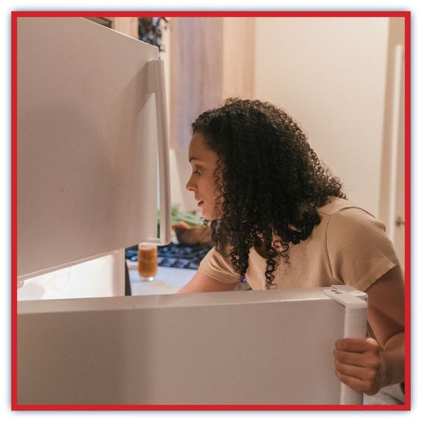 woman getting into fridge