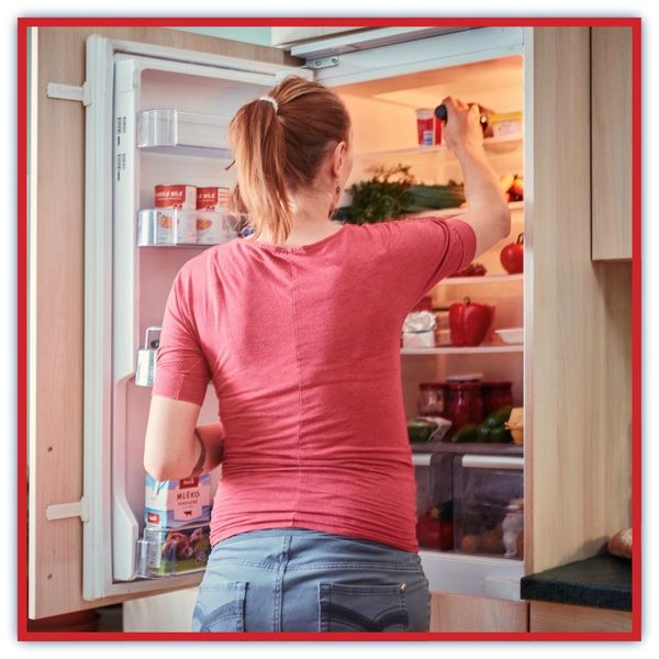 woman getting into fridge