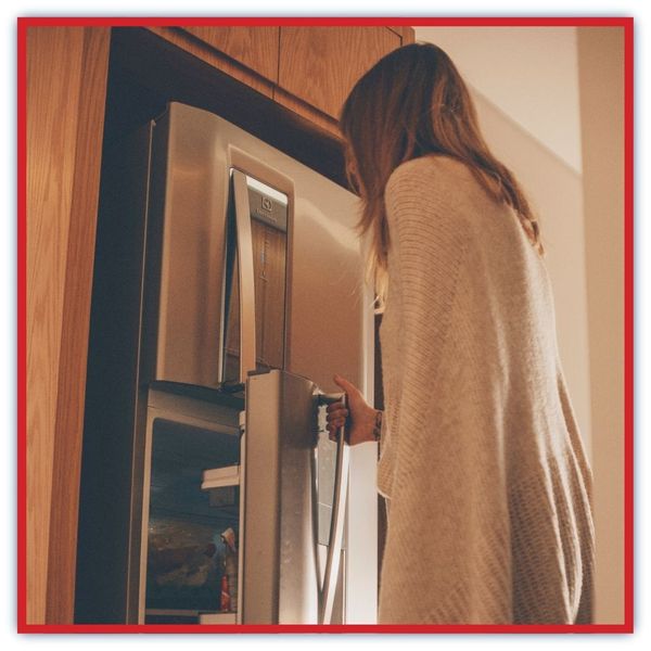 woman getting into fridge