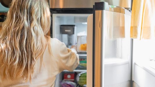 woman getting into fridge