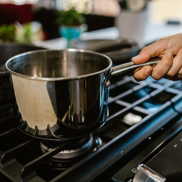 person placing pot on stovetop