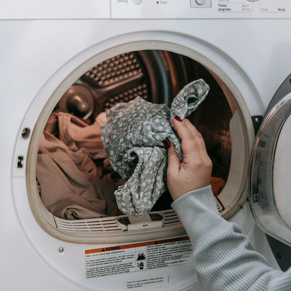 person throwing shirt into washer