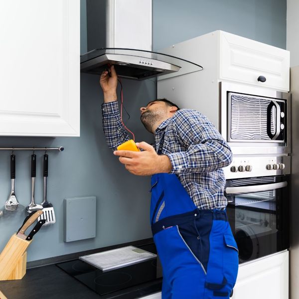 A repairman inspecting an over hood