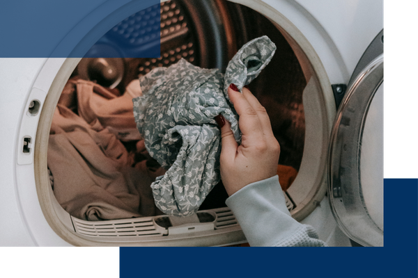 putting clothes into a dryer