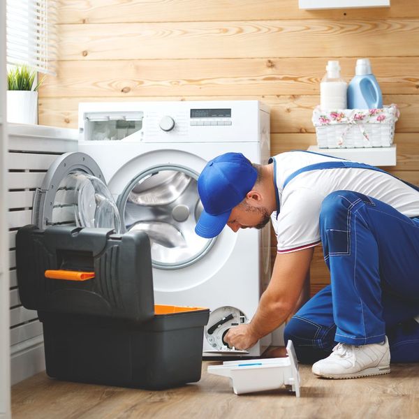 repair man fixing washer