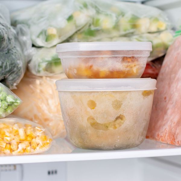 A variety of foods in containers and plastic bags in a freezer