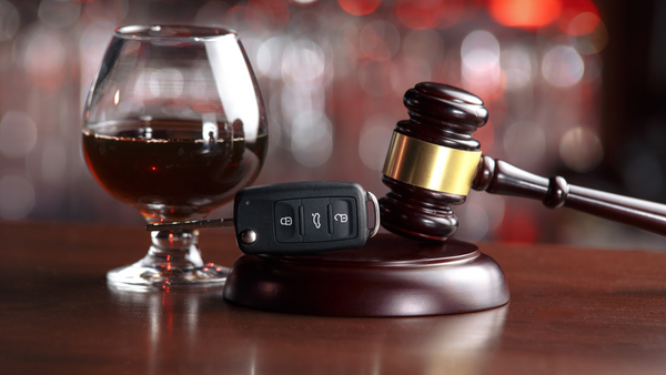 Gavel alongside an alcoholic beverage and car keys