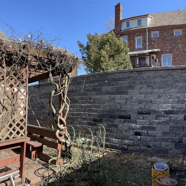 trellis and benches under tall retaining wall