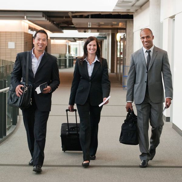 3 business employees walking with luggage