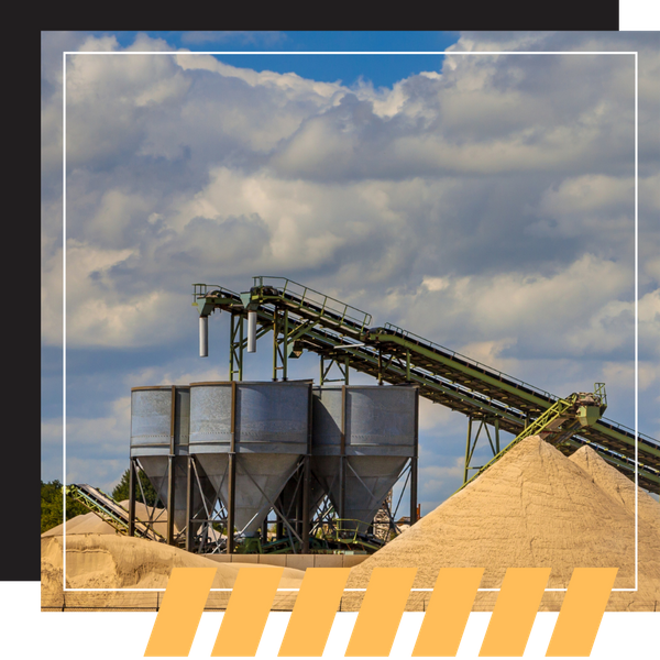 Large industrial silos and conveyor belts used for processing sand and gravel.