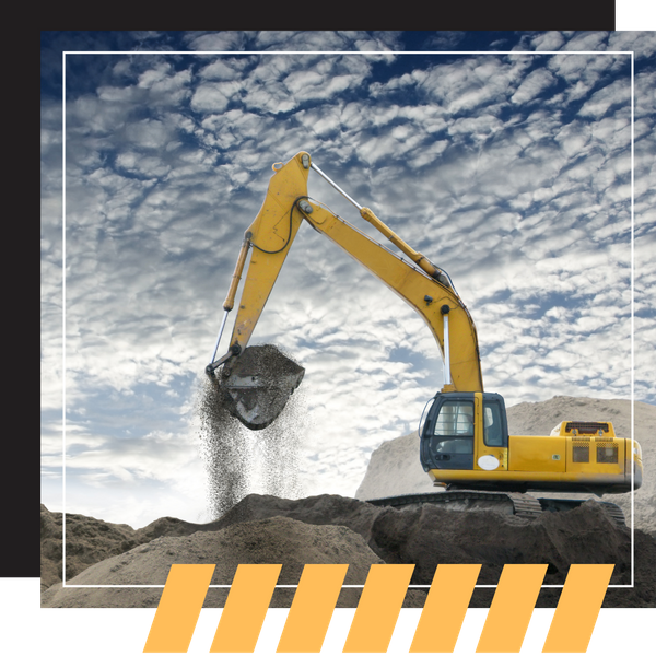 A yellow excavator lifting a bucket of gravel against a dramatic, cloudy sky.