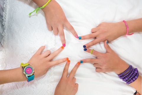 5 girls making a star with their fingers, friendship bracelets and colorful nails