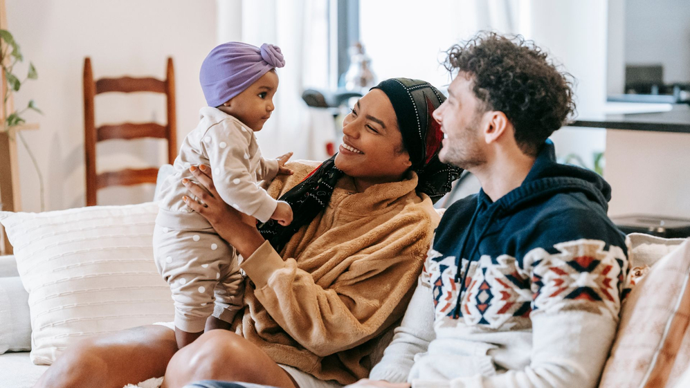 family holding a baby in new home 