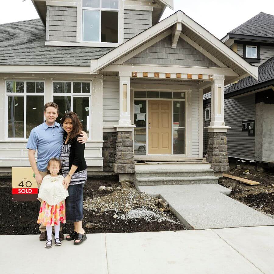 family standing in front of new house