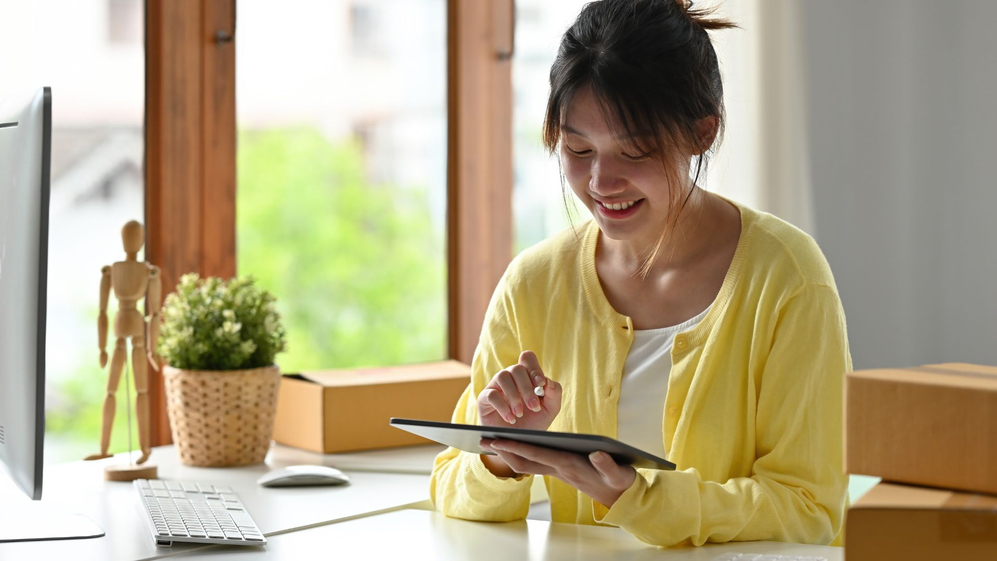 woman smiling at an ipad 