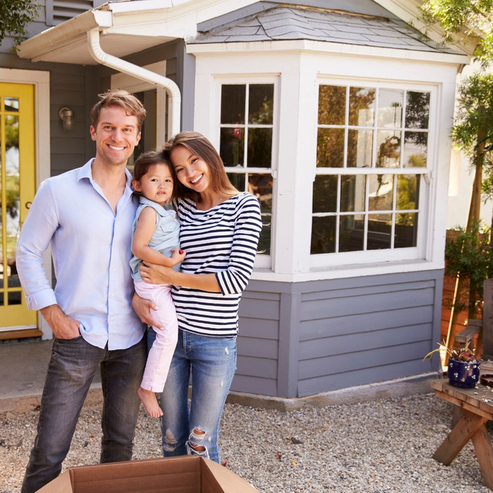 Family standing in front of their new home.
