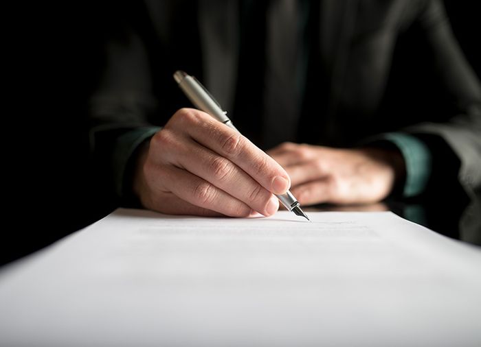 Image of someone signing forms