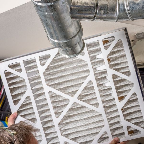 HVAC tech replacing air filter