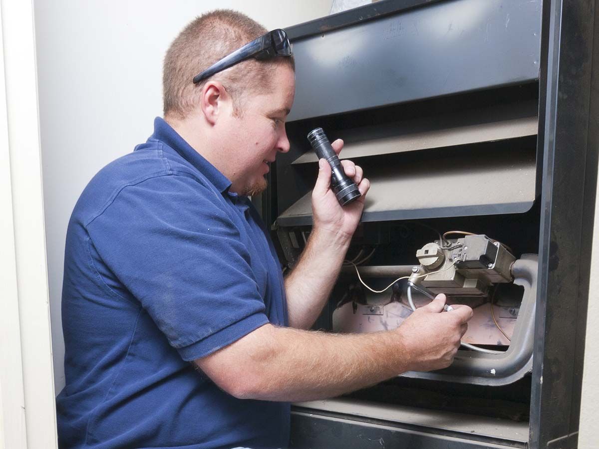 Repairman tuning up a furnace