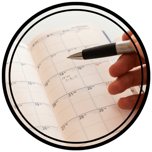 a person writing in their calendar a person writing in their calendar