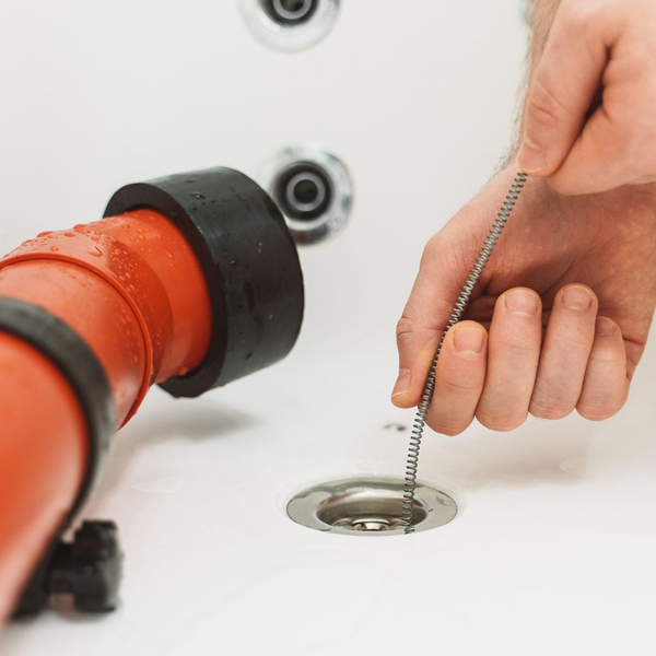 A plumber performing a drain cleaning service