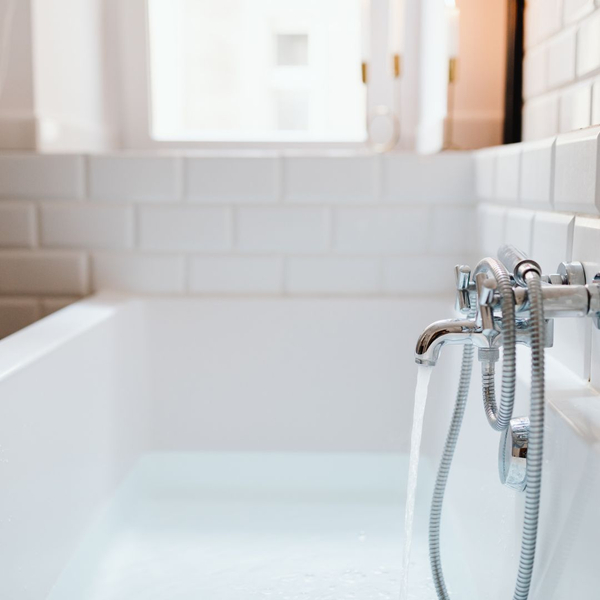 Water flowing smoothly from a faucet in a bathtub
