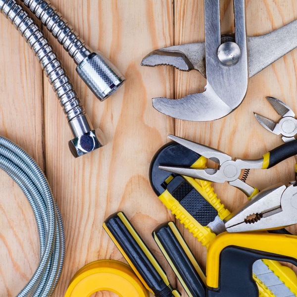 Plumbing tools, pipes, and hoses laid out on a table