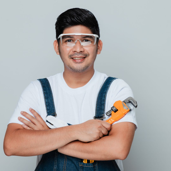 Plumber holding a wrench smiling at the camera