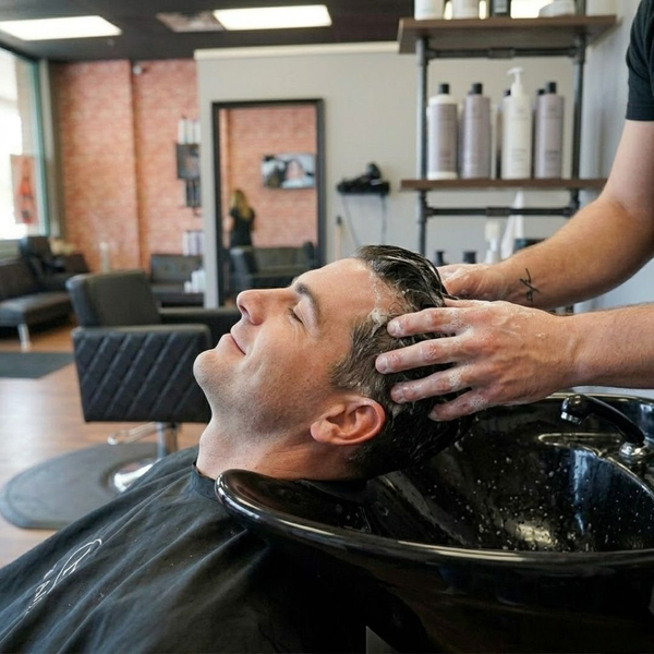 A man enjoying a relaxing scalp massage and shampoo treatment at a professional salon.