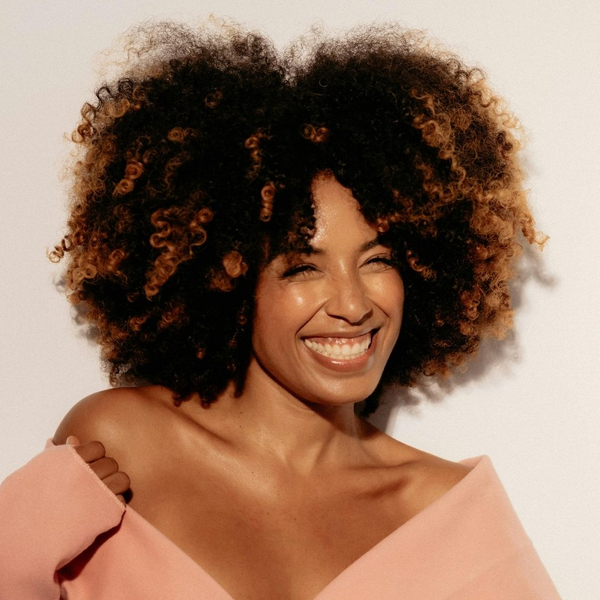 Happy woman with large, healthy natural curly hair.