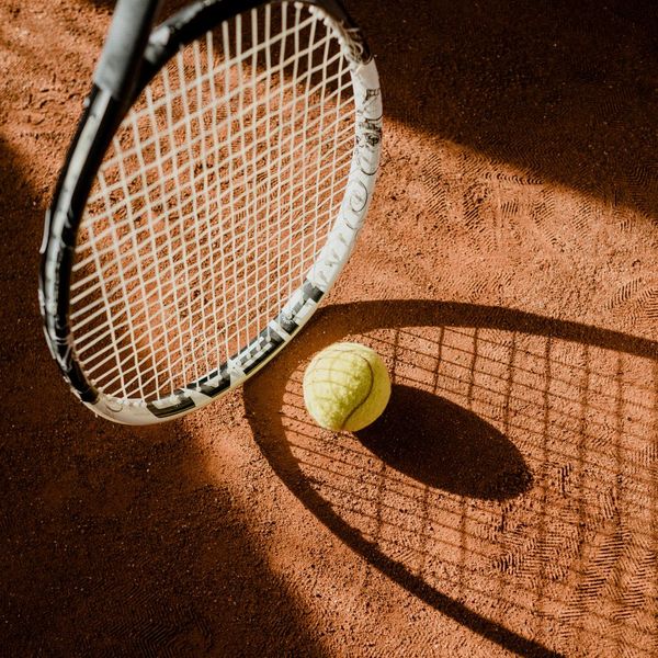 Tennis racquet on court with a tennis ball