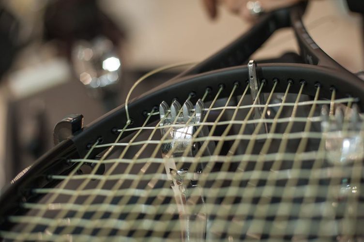 Tennis racket clamped in stringing machine Tennis racket clamped in stringing machine