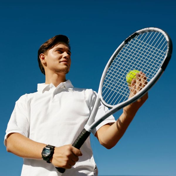 Tennis player holding racquet and ball